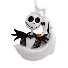 a white ceramic figurine with a skeleton on it's back holding a jack - o - lantern