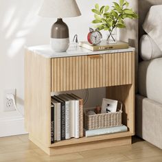 a nightstand with books and a lamp on it next to a couch in a living room