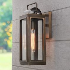 an outdoor wall light on the side of a house with two lights attached to it