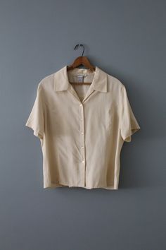 Vintage cropped silk top in beige color. Tie back closure. Button down front. 100% silk Made by Anna & Frank Fits like large: 16" shoulders  42" bust 22" length 9" sleeves Excellent condition! (Small stain, see last photos) Summer Beige Silk Blouse, Elegant Cream Cropped Tops, Elegant Cropped Cream Top, Beige Silk Blouse For Summer, Beige Silk Tops For Work, Formal Cropped Top For Summer, Beige Silk Tops For Workwear, Formal Beige Short Sleeve Blouse, Elegant Cropped Silk Tops