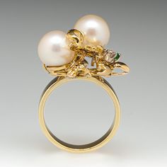 This incredible cocktail ring features an organic design and is accented with two (2), post set, cultured saltwater pearl, two (2), prong set, round single cut diamonds and three (3), prong set, round mixed cut natural emeralds. The ring measures 26.0mm at the top, rises 14.2mm above the finger, tapering to 3.4mm wide and 1.1mm thick at the base of the shank. This ring is currently a size 4.75. Formal Multi-stone Pearl Ring In Fine Jewelry Style, Elegant Multi-stone Gold Pearl Ring, Elegant Yellow Gold Multi-stone Pearl Ring, Elegant Formal Multi-stone Pearl Ring, Emerald Cocktail Ring, Emerald Cocktail, Saltwater Pearls, Aquamarine Jewelry, Organic Design