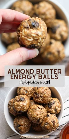 a hand holding a peanut butter energy ball over a bowl of fruit