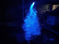 a blue light hanging from a wire in the dark