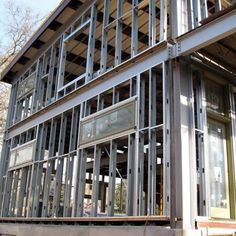 a building that is being constructed with metal bars on the side and windows all around it