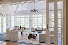 a living room filled with furniture and lots of windows