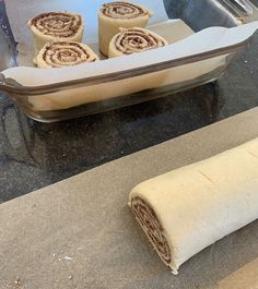 some food is laying out on the counter next to a pan with rolls in it