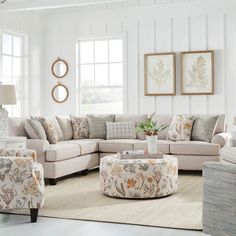 a living room filled with lots of furniture next to two windows and a rug on the floor