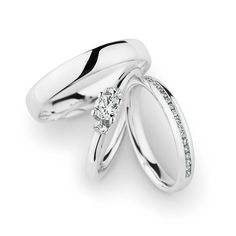 two white gold wedding rings with diamonds on each one and the other in between them