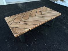 a wooden bench sitting on top of a black gravel ground next to a white door