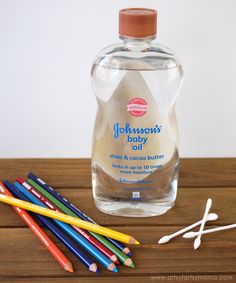 a bottle of johnson's baby oil next to colored pencils