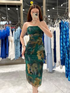 a woman taking a selfie in a dress shop