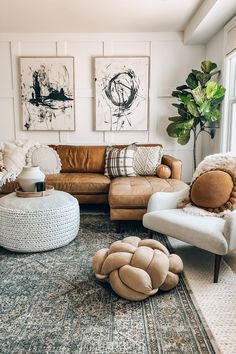 a living room filled with lots of furniture and paintings on the wall above it's windows