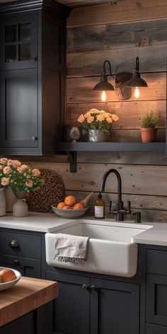 a kitchen with black cabinets and white sink in the center, surrounded by oranges