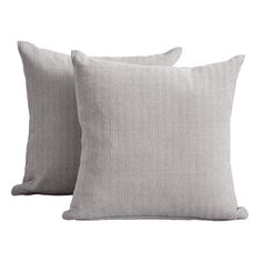 two grey pillows sitting next to each other