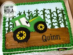 a birthday cake with a tractor on the side and name written in green icing