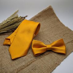 We proudly present our solid marigold tie collection.-Hand-sewn semi skinny Adult Neck Tie -Pre-tied Bow tie available from Newborn up-to Adult size with adjustable strap. (Bow tie stitched into place)-Pocket square.Material: 100% Wool interliningMeasurements: The necktie is 54” or 137cm in lengthThe widest part measures 2 3/4” or 7 cmPocket square measure approximately 10”  squares.Our experienced team has over 100 years worth of professional sewing experience combined.Our items are produced to Formal Gold Suit And Tie Accessories With Decorative Bow, Gold Bow With Tie Back For Wedding, Gold Bow Ties For Black Tie Events, Classic Gold Bow For Black Tie Events, Dapper Gold Accessories For Black Tie Suit, Gold Tie For Father's Day, Gold Suit And Tie Accessories For Wedding, Gold Bow With Ties For Gifts, Elegant Yellow Bow Tie For Black Tie Events