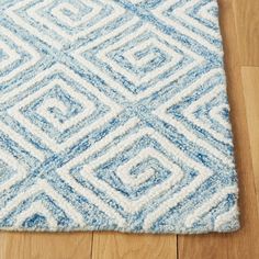 a blue and white rug on top of a wooden floor next to a wood floor