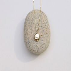 Wishing Stone Necklace, Gold Pebble Necklace, Diamond Pebble Pendant, Gold Diamond Charm, Solid Gold Pebble Necklace They say a pebble with a continuous white line around it is a wishing stone that can grant your deepest desire. This is not that stone. This gold and diamond pebble stands for something more empowering: You can grant your deepest desire. No matter how impossibly big your dream may seem, at its heart is something entirely within reach: the freedom of becoming who you most want to b Diamond Pendant Necklace For Keepsake, Keepsake Diamond Necklace In White Gold, Keepsake White Gold Diamond Necklace, Minimalist Oval Pendant Keepsake Jewelry, Timeless Oval Pendant Diamond Necklace Gift, Timeless Oval Pendant Diamond Necklace As Gift, Delicate Oval White Gold Necklaces, Minimalist Oval Jewelry With Diamond Accents, Oval Pendant Diamond Necklace For Gift