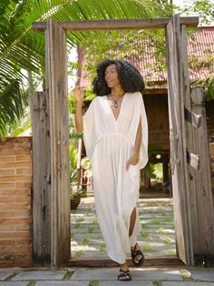 Introducing our Acacia Cotton Linen Goddess Dress in off-white, a stunning addition to our Goddess Collection. This dress is lovingly handcrafted with 100% cotton-linen and is ideal for both casual beach days and elegant nights out. The elastic waistband and bat-wing sleeves offer a feminine, bohemian style, while the lightweight fabric and two side pockets ensure comfort and versatility. Plus, the self-belt highlights the waist for a flattering touch. Features: Soft cotton linen-blend, no linin Beige V-neck Linen Dress For Beach, Bohemian Linen Dress For Summer Day Out, Bohemian Linen Dress For Summer, White Breezy Dresses With Relaxed Fit, White Breezy Dress With Relaxed Fit, White Tunic Dresses For Beach Season, White Tunic Dress For Beach Party, Summer Linen Dress For Daywear, Summer Linen V-neck Dress For The Beach