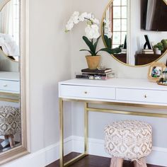 a white desk topped with a mirror and a small stool next to it on top of a hard wood floor