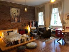 a living room filled with furniture and a brick wall