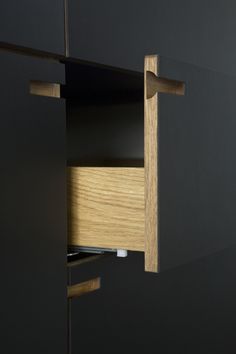 an open cabinet with drawers in the middle and one drawer on the other side that is closed