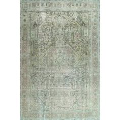 an antique rug with green and blue colors on the ground, in front of a white background