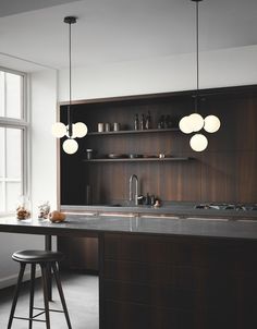 a kitchen with an island and bar stools in front of the countertop area