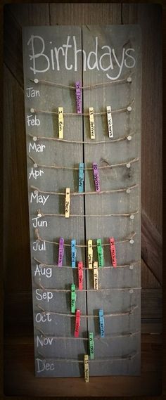 a birthday sign hanging on the side of a wooden door with clothes pins attached to it