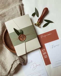 the wedding stationery is laid out on top of each other, including an envelope with a wax stamp