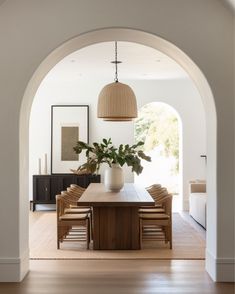 a dining room with an archway leading into the living area