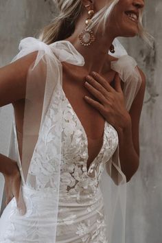 a woman in a white wedding dress with her hands on her chest