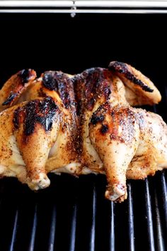 a chicken is cooking on the grill with it's legs still in the oven