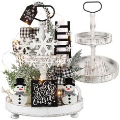 an assortment of christmas decorations on display in a white tray with snowflakes and ribbons