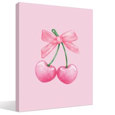 a pink canvas with two cherries and a bow on the top, against a white background