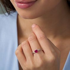 a woman wearing a diamond and ruby ring