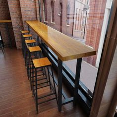 there are many stools at the bar by the window in this restaurant that is empty