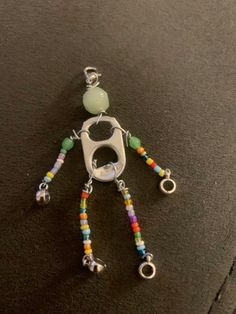 a keychain with beads and charms attached to it on a black surface next to a pair of scissors