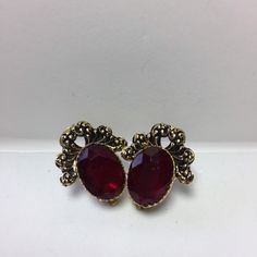 Wonderful set of vintage rhinestone ruby red color Earrings. 1970's clip on. These lucite earrings are a beautiful deep red color.Antiqued gold tone settings. Please see photos. Box may vary. Vintage Ruby Evening Jewelry, Red Jeweled Earrings For Evening, Formal Jeweled Clip-on Costume Jewelry Earrings, Costume Jewelry Jeweled Clip-on Earrings For Formal Occasions, Costume Jewelry Style Jeweled Clip-on Earrings For Formal Events, Costume Jewelry Clip-on Earrings With Jewels For Formal Events, Formal Costume Jewelry Clip-on Earrings, Red Formal Costume Jewelry Earrings, Red Costume Jewelry Earrings For Formal Occasions