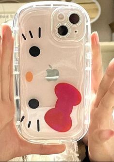 a person holding up a phone case with a hello kitty design on it