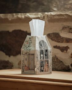 a tissue dispenser sitting on top of a wooden table