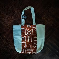 - Lightweight, square shaped tote with African print - one of a kind - 13 1/2 x 13 1/2 x 4 inches - Straps hang 10 inches down White Hand Printed Bag For Daily Use, White Hand Printed Bag For Everyday Use, White Hand Printed Bags For Daily Use, White Hand Printed Bags For Everyday Use, Eco-friendly Orange Tote Shoulder Bag, Hang 10, Orange Pattern, Tote Pattern, Diy Bag