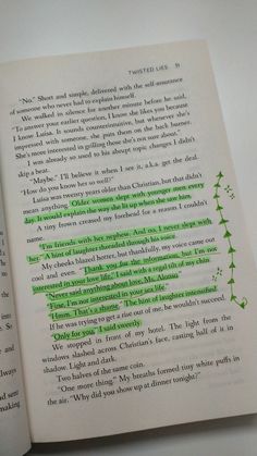 an open book with green writing on it