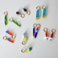 several different colored plastic objects are arranged on a white surface, including key chains and rings