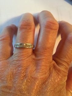 an older woman's hand with a ring on top of her finger, showing the middle finger