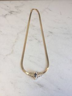 "An incredible 14kt Yellow Gold Lady's Diamond and Sapphire Necklace in 16\" consisting of 1- 8mm x 4m .75ct approx. total weight Genuine Marquise Sapphire with .50ct total weight of diamonds SI1/SI2 clarity, G color prong and channel set surrounding the gemstone with a flat 4mm Herringbone style chain with a heavy box clasp. This show stopper will lighten up any evening when worn. Sapphire is the Birthstone for September. The total weight of this Necklace is 14.5 grams. This item would Retail f Marquise Gemstone Necklace For Formal Occasions, Formal Marquise Gemstone Necklace, Gold Marquise Diamond Necklace For Formal Events, Timeless 14k Gold Necklace For Evening, Luxury Formal 14k Stamped Necklaces, Elegant White Gold Snake Chain Necklaces, Elegant Polished Snake Chain Necklace, Elegant Snake Chain Necklace With Polished Finish, Luxury Marquise Gemstone Necklace