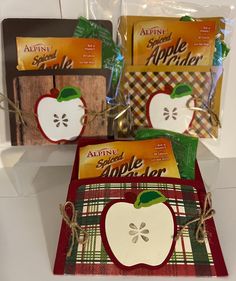 four apple themed gift bags with tags on them