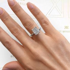 a woman's hand with a diamond ring on it