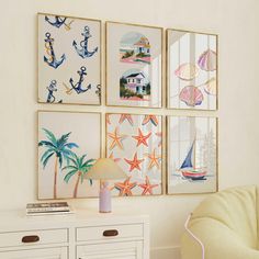 four framed pictures hang on the wall above a white dresser