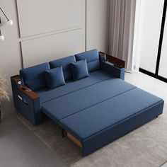 a blue couch sitting on top of a rug next to a window